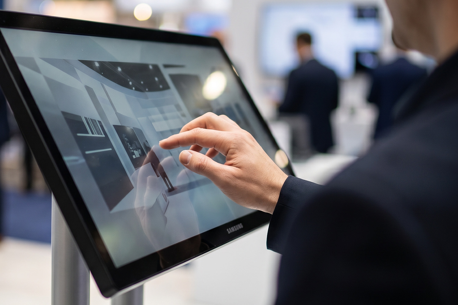 Person bedient Touchscreen auf Messe
